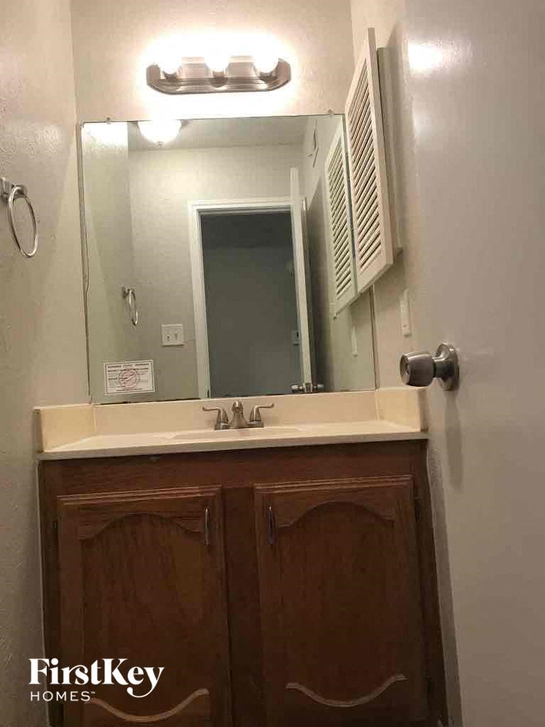 A bathroom with a sink and a mirror above it.