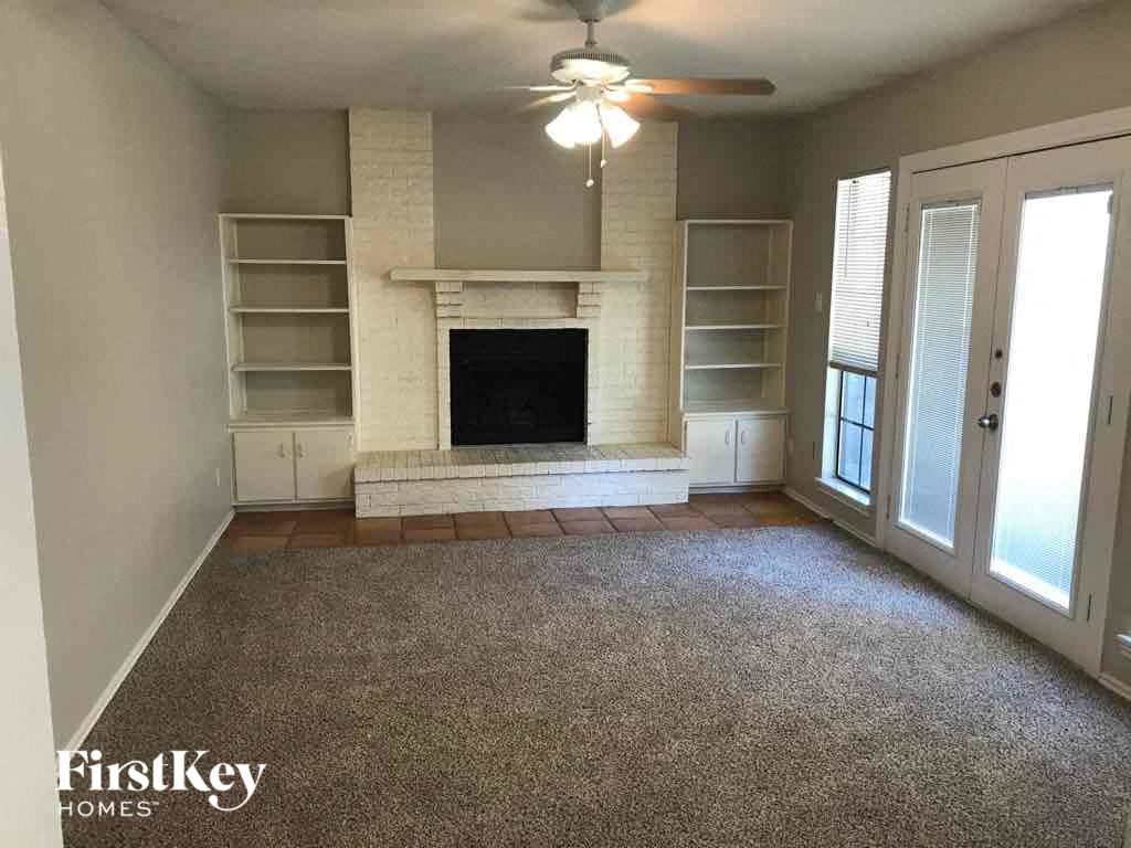 A living room with a fireplace and a fan.