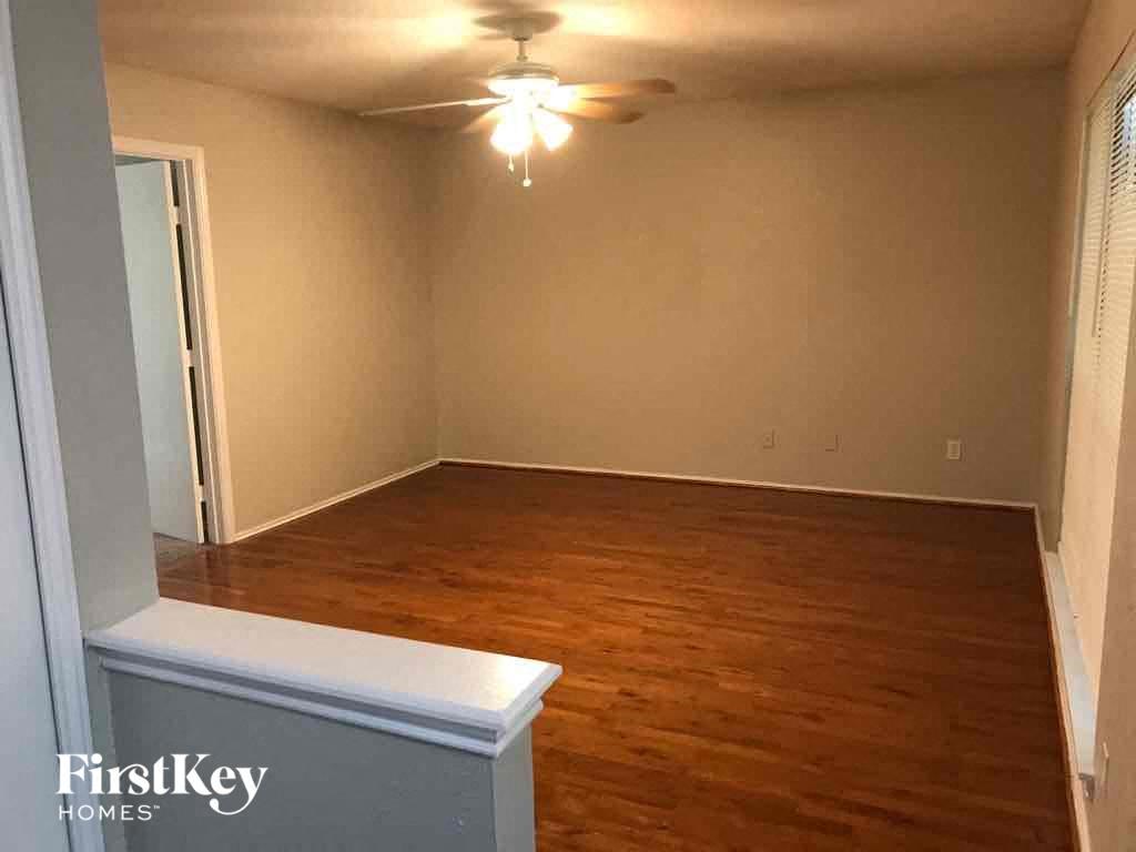 A room with wooden flooring and a ceiling fan.