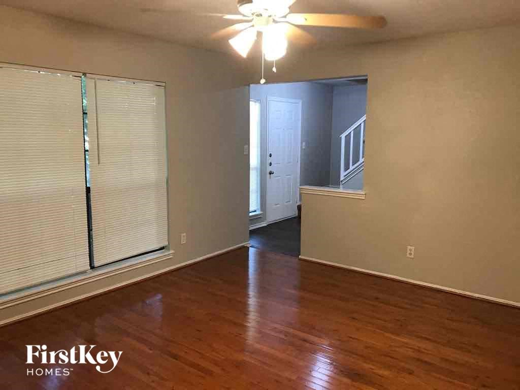 A room with wooden floors and a ceiling fan.