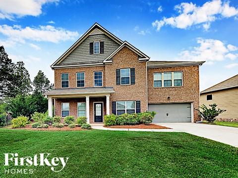 a large brick house with a lawn in front of it
