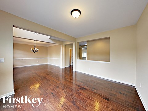 an empty living room with wood flooring and white walls