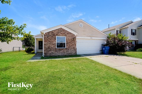 a small brick house with a lawn in front of it
