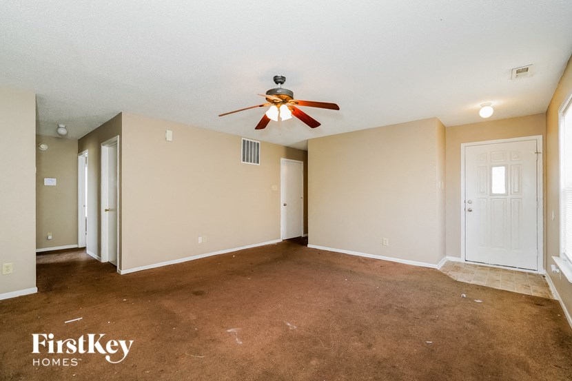 a empty living room with a ceiling fan