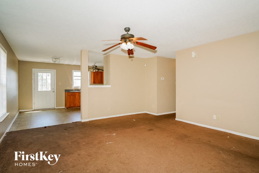 a empty living room with a ceiling fan