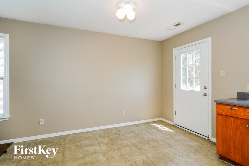 a empty living room with a door and a dresser