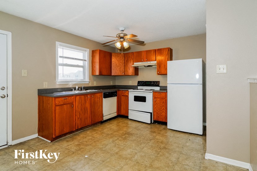 a kitchen with white appliances and wooden cabinets