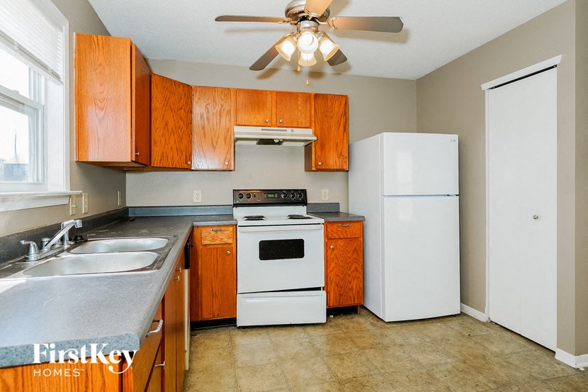 a kitchen with white appliances and wooden cabinets