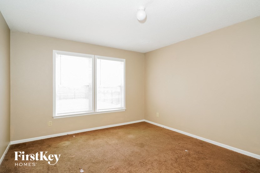 a room with a carpet and two windows
