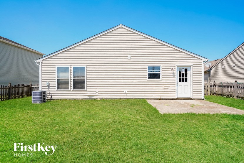 a small white house with a grassy yard in front of it