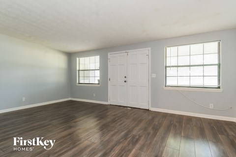 the living room of a house with wood floors and a white door