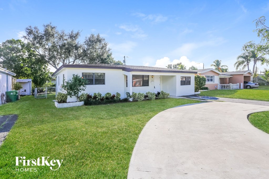 a white house with a yard and a driveway