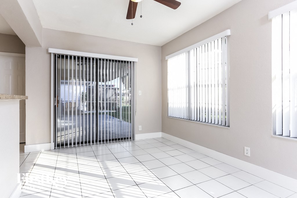an empty living room with a sliding glass door to a patio