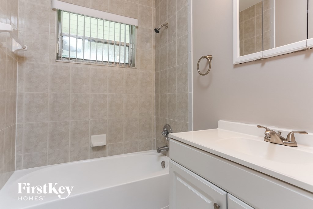 a bathroom with a tub and a sink and a mirror
