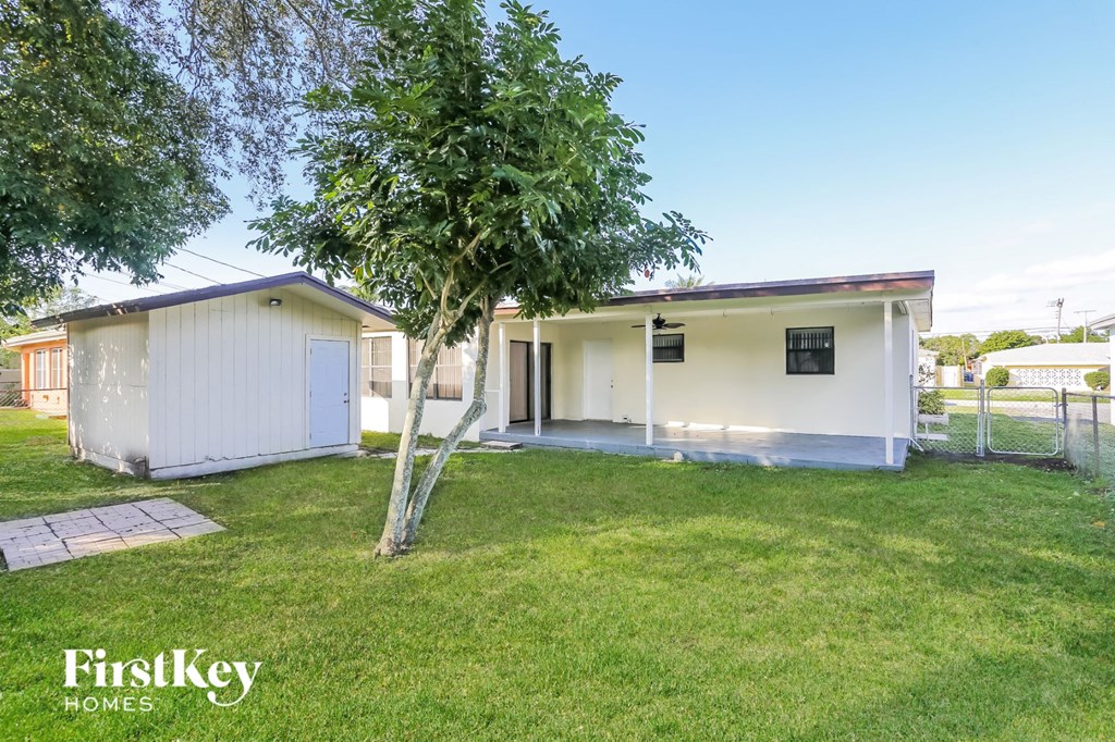 a small white house with a tree in the yard