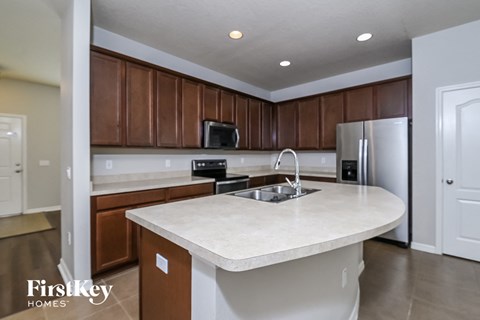A kitchen with brown cabinets and a white island.