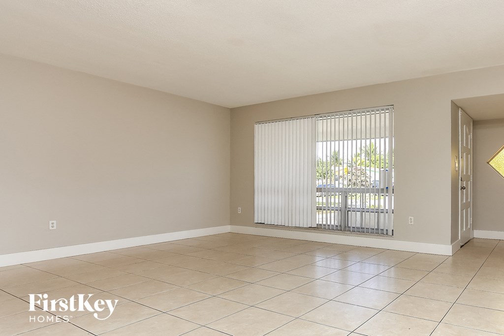 a living room with a large window and a tiled floor