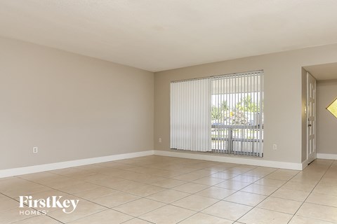 a living room with a large window and a tiled floor