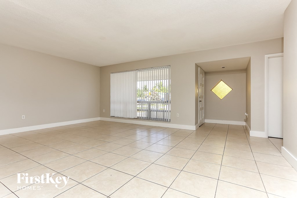 an empty living room with a sliding glass door to a patio