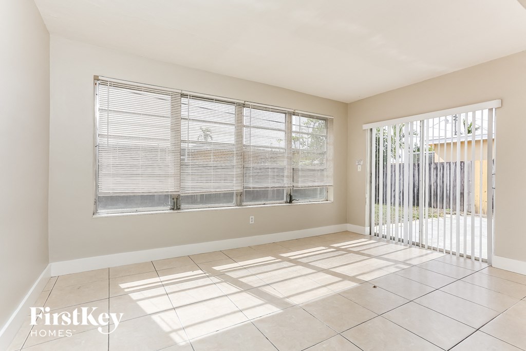 an empty living room with a large window and a sliding glass door