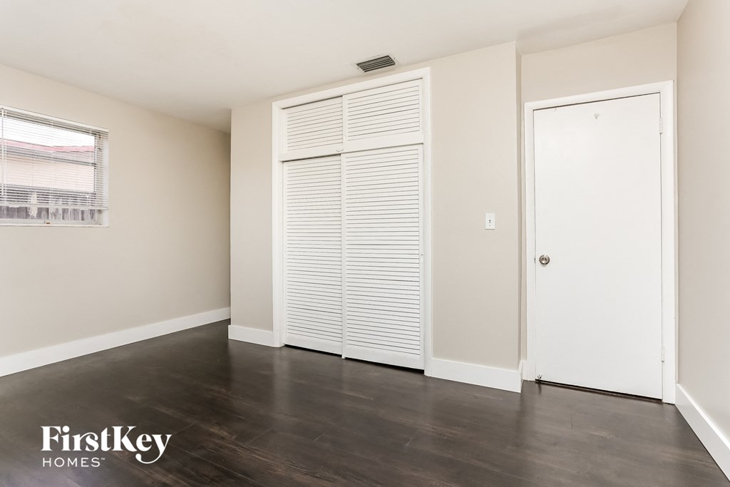 a clean and empty room with a closet and a door