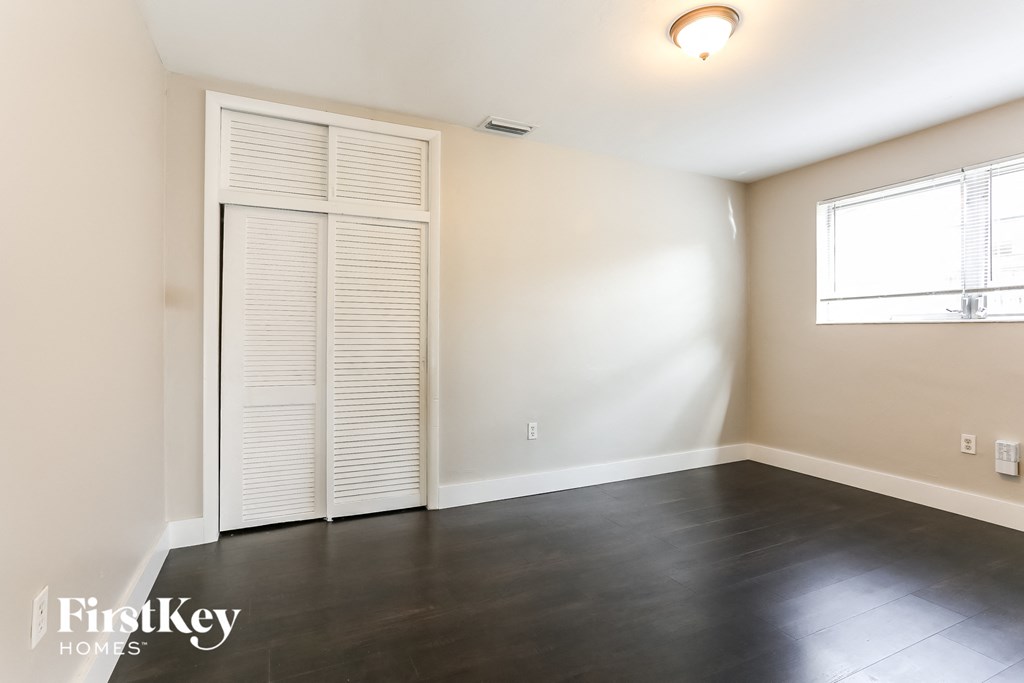 an empty living room with white walls and a window and a door