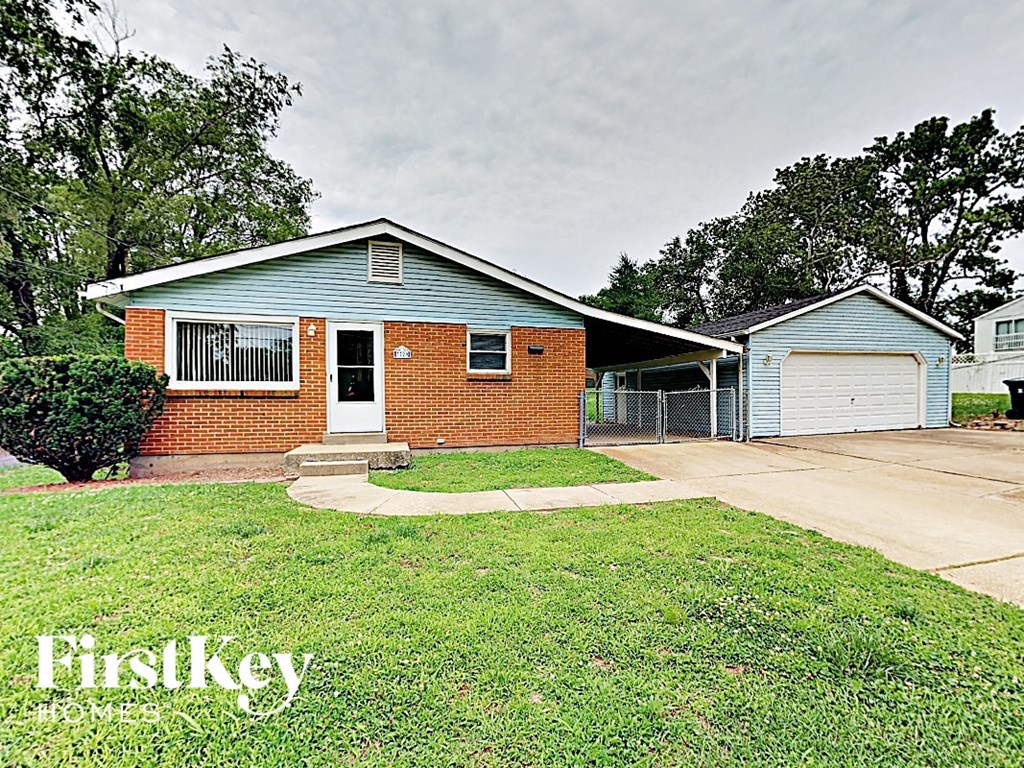 A brick house with a garage is for sale.