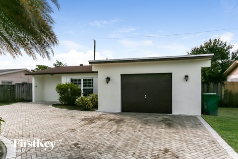 a home with a brick driveway and a garage door