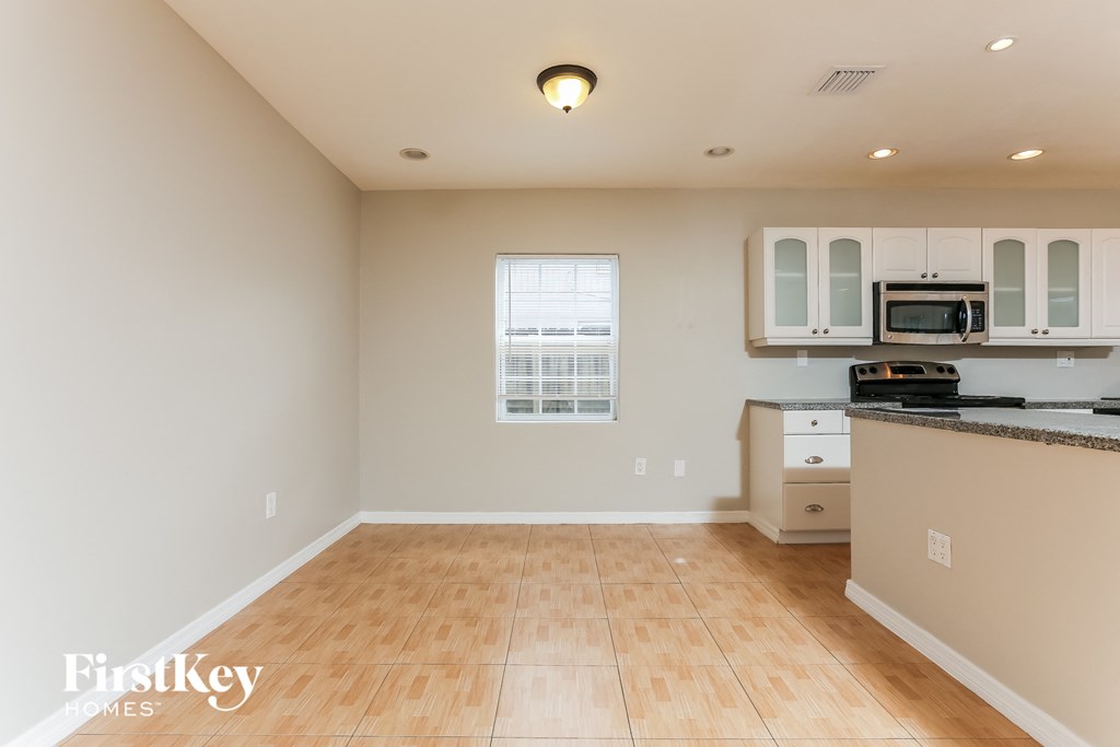 a kitchen with a hard wood floor and white cabinets