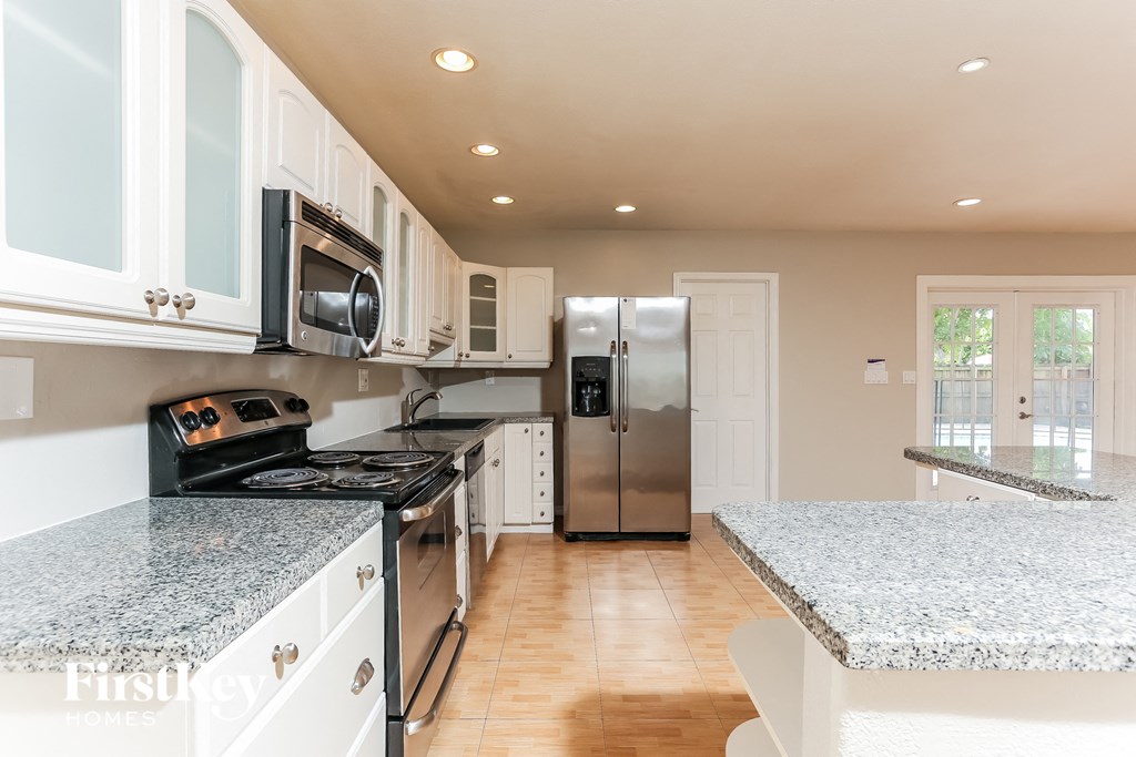 a kitchen with granite counter tops and stainless steel appliances