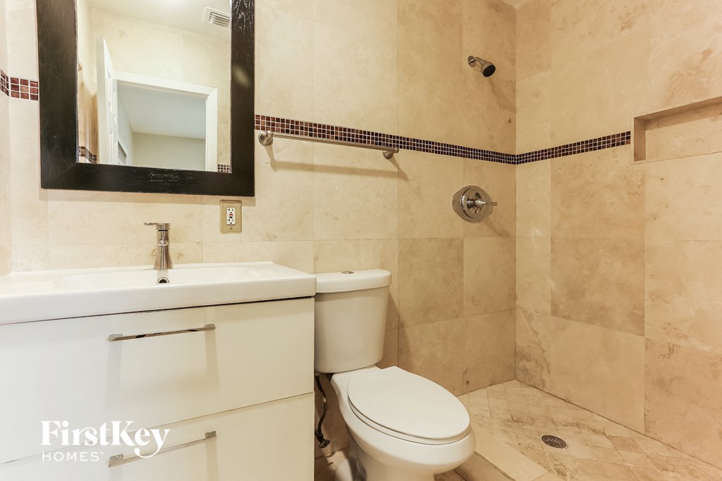 a bathroom with a toilet and a sink and a mirror