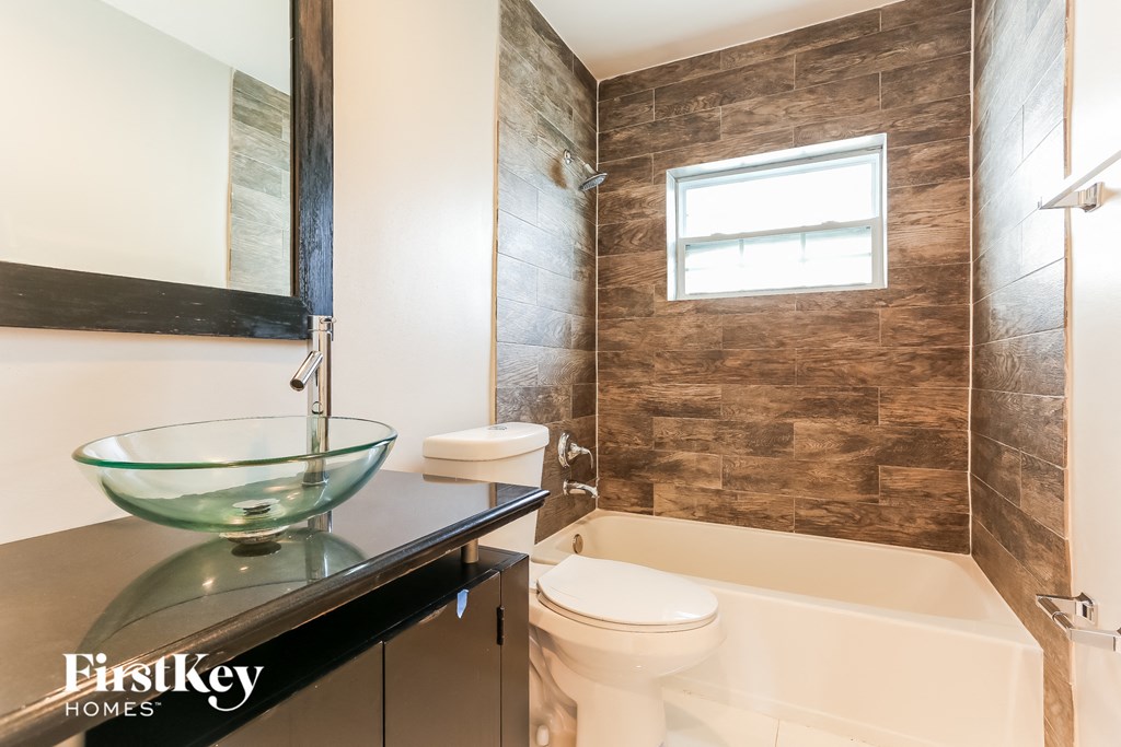 a bathroom with a toilet sink and tub and a mirror