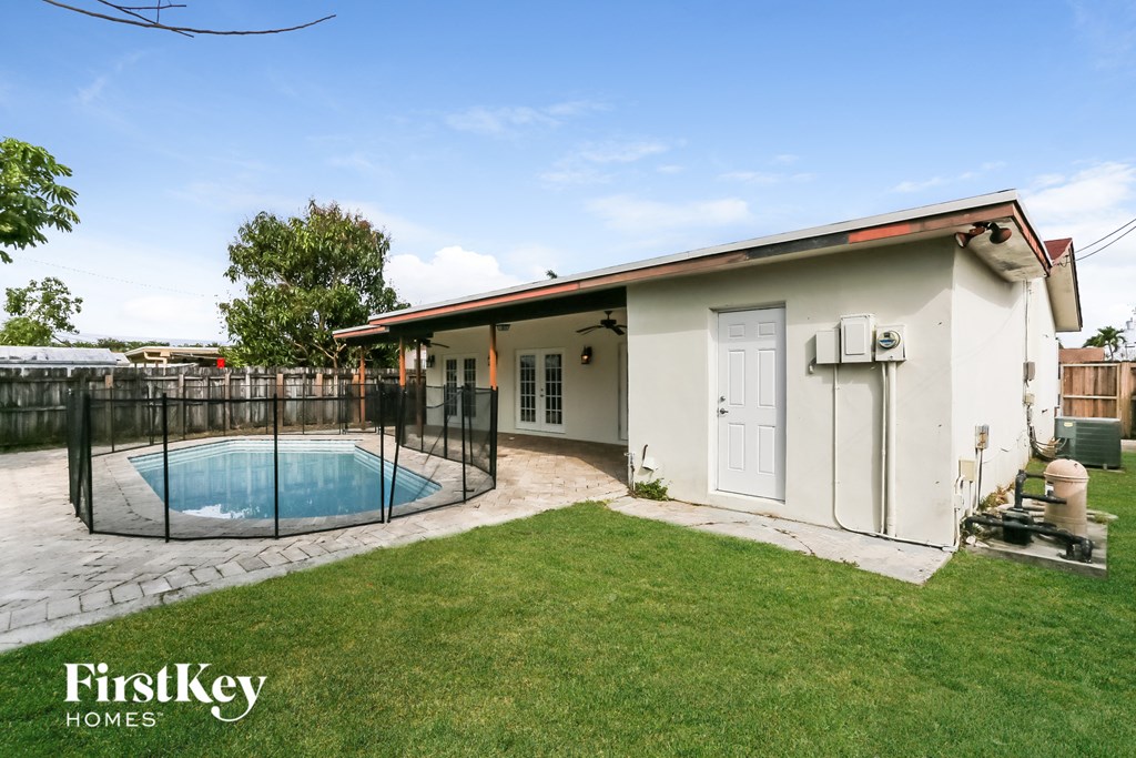 a backyard with a pool and a small house