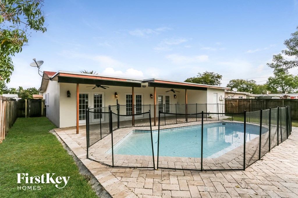 a house with a pool and a fence around it