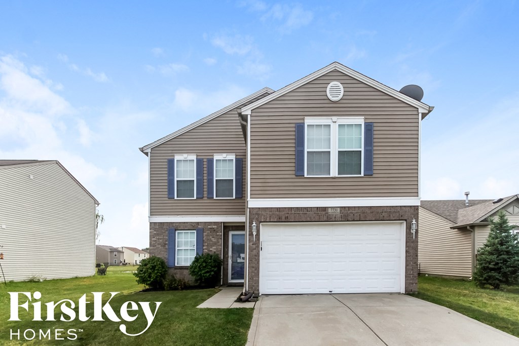 a tan and brown house with a white garage door