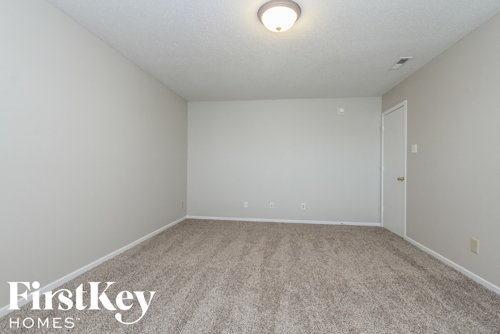 a empty room with carpet and white walls