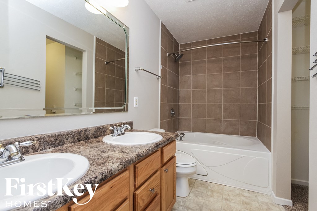 a bathroom with two sinks and a shower and a toilet