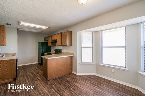 A kitchen with wooden cabinets and a green fridge.