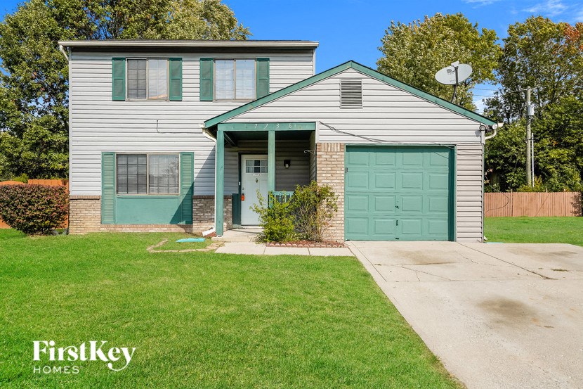 a blue and white house with a green garage door