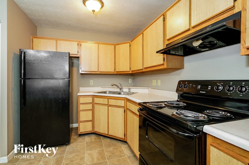 a kitchen with black appliances and wooden cabinets