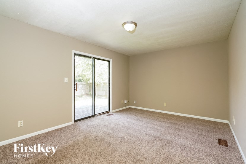 an empty living room with a door to a patio