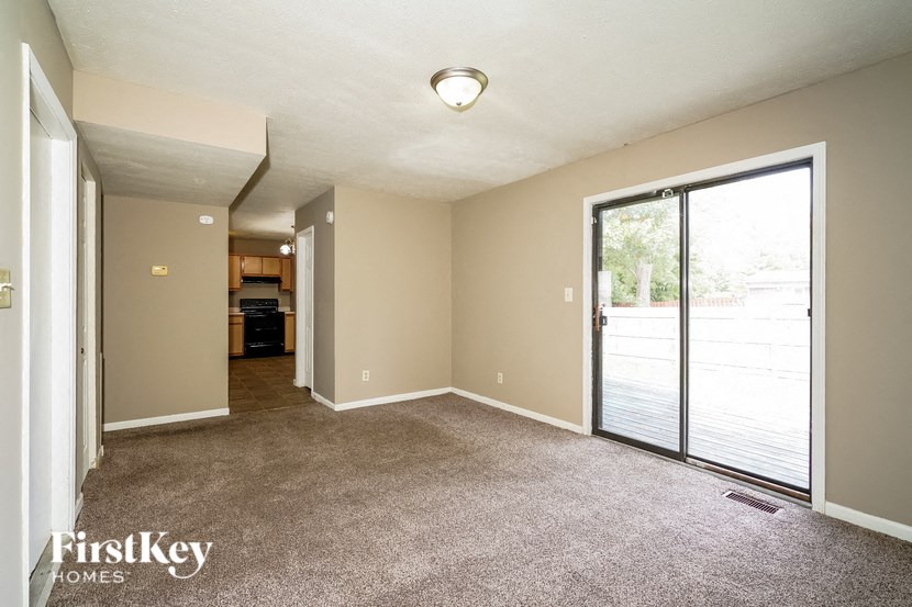an empty living room with a sliding glass door to a patio