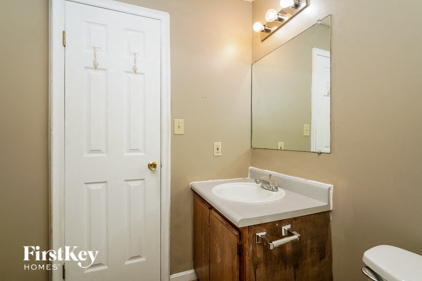 a bathroom with a sink and a mirror and a white door