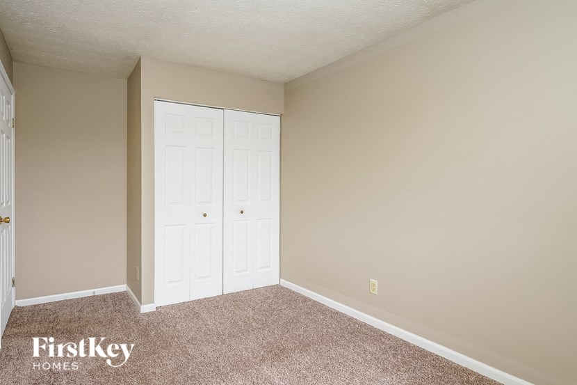 a bedroom with two closets and a carpeted floor