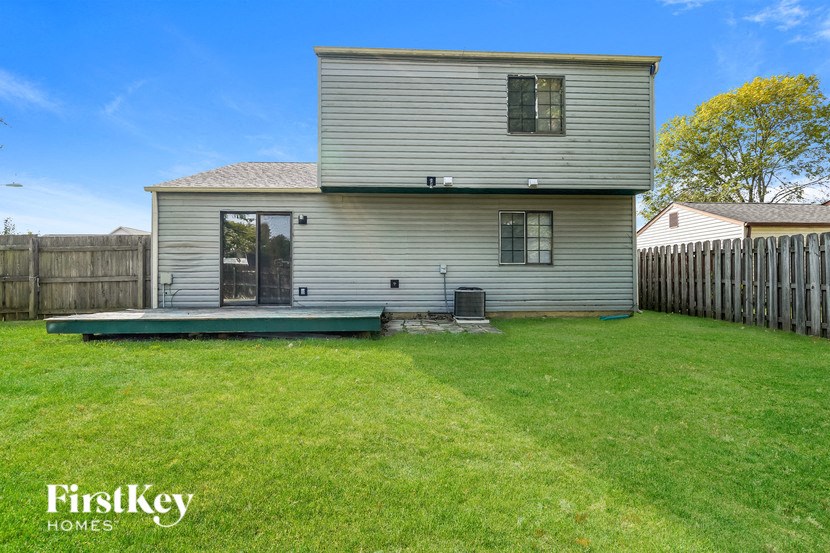 the back of a house with a yard and a deck