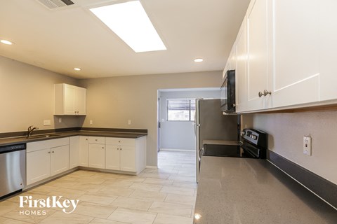 a kitchen with white cabinets and a stainless steel refrigerator and a sink