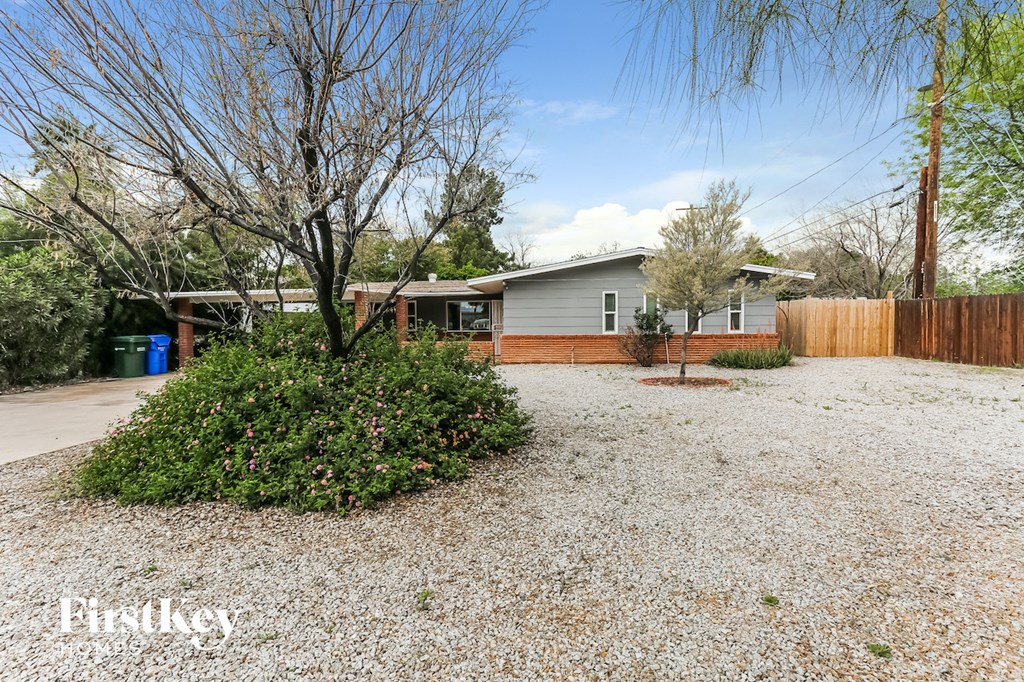 a gravel driveway with a house in the background