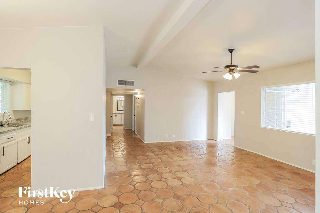 an empty kitchen and living room with a ceiling fan