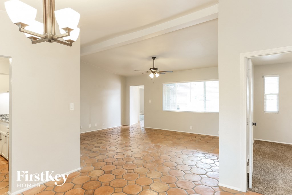 an empty kitchen and living room with a ceiling fan