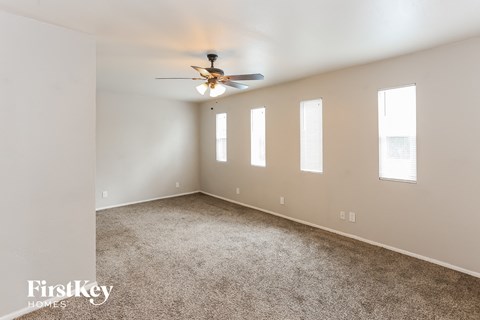 a living room with carpet and a ceiling fan